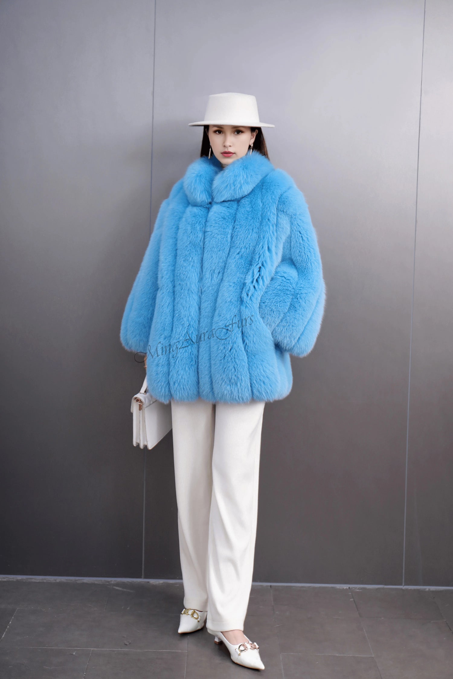 Front view of thick and plush white fox fur coat for women with subtle blue undertone